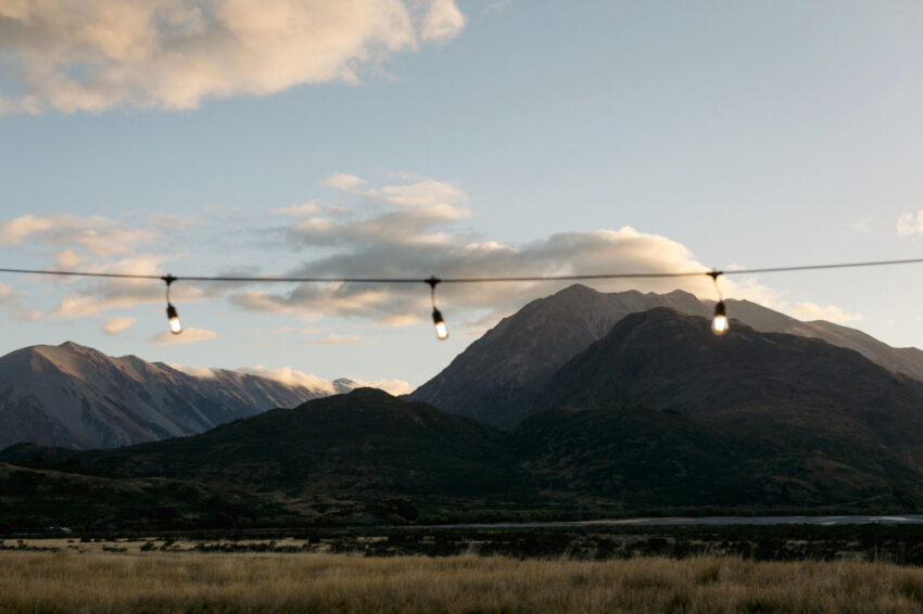 Sun fading on distant mountains with festoon lights in foreground