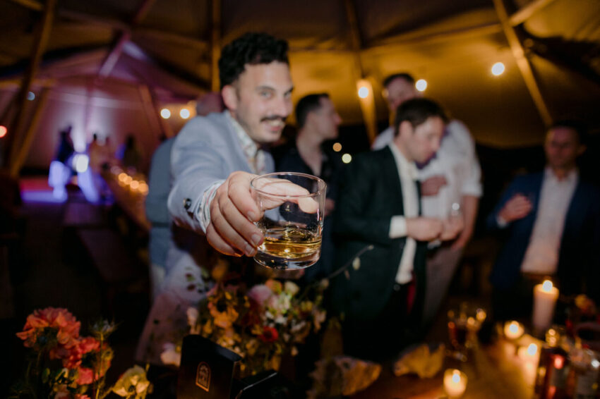 Guest offering photographer whisky