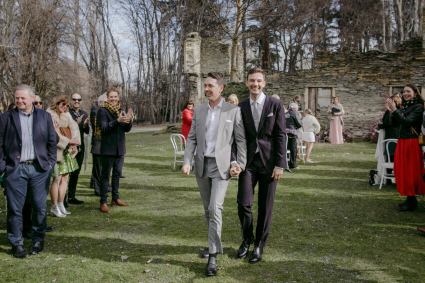 Liam and Steve just married, walking back down the aisle with huge smiles