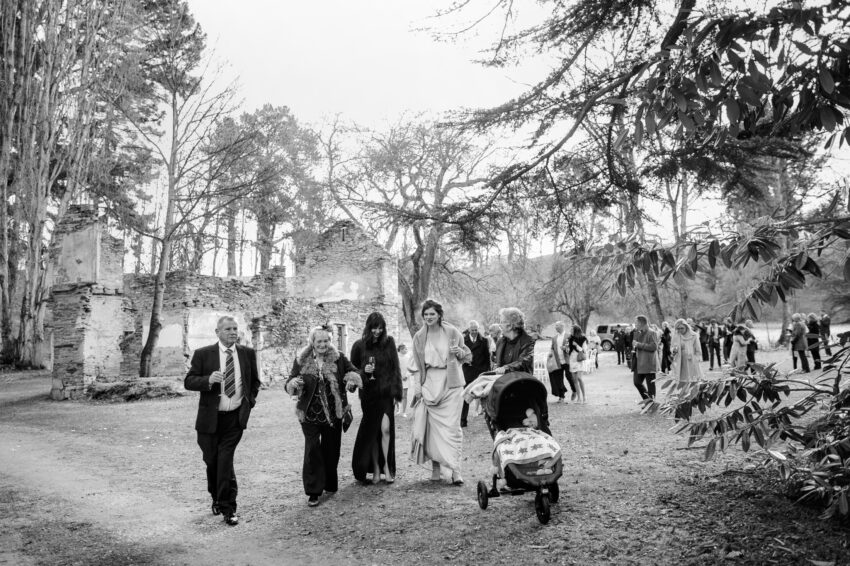 Guests walking between venues, with Thurlby Domain ruins in the background