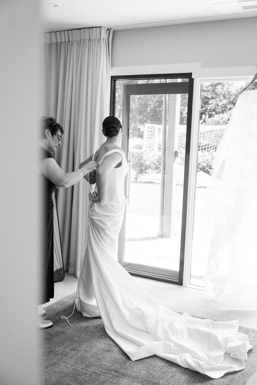 Bride getting dressed with help from her mum