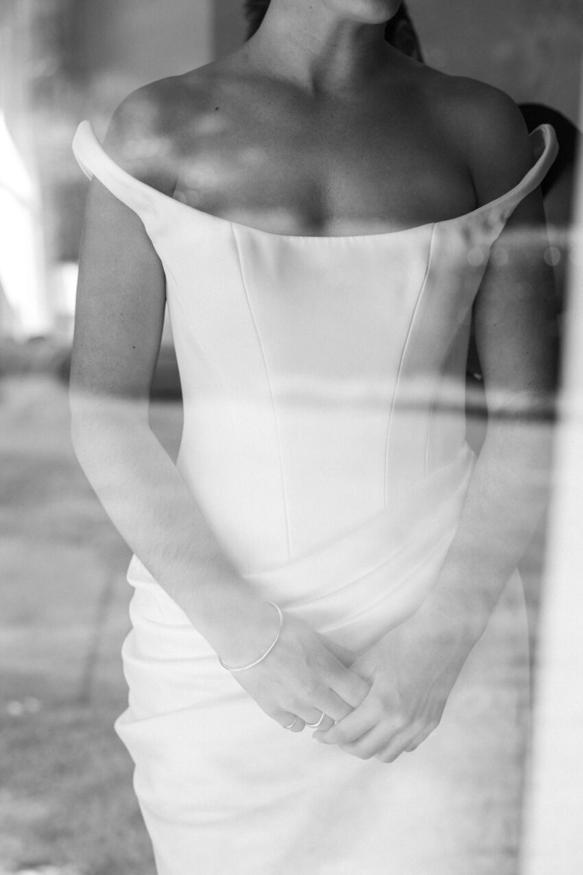 image of brides torso through a window as shes getting dressed