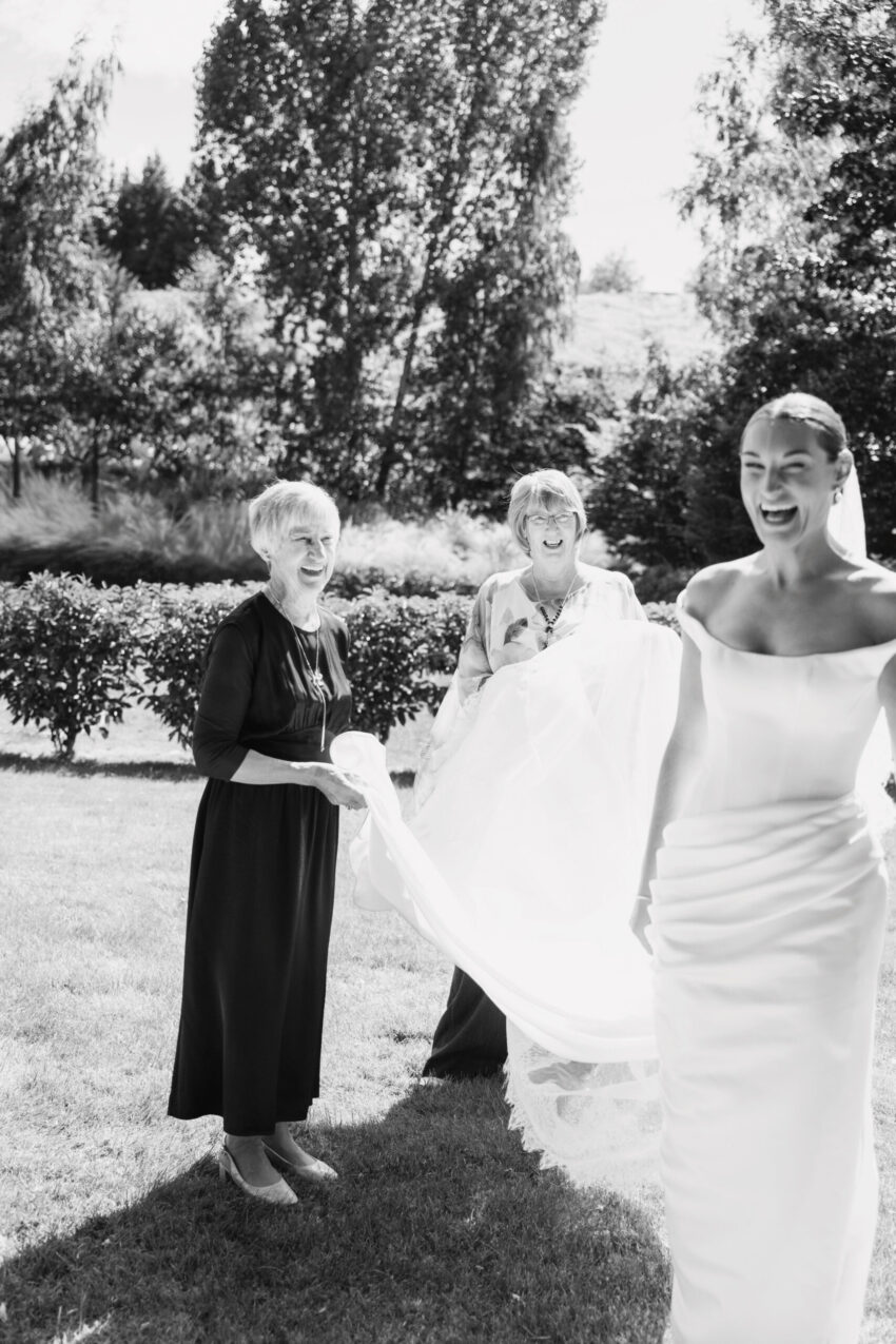 Candid of the bride and two grandmas lifting her veil