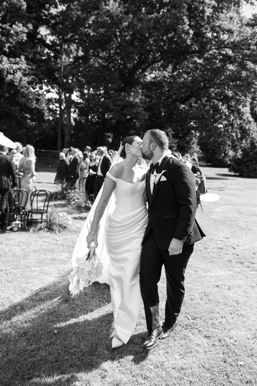 Bride and groom kissing again as they walk away