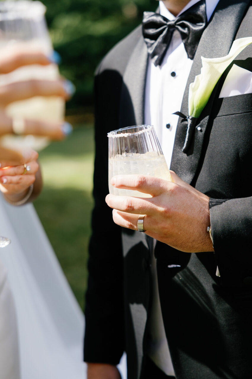 close up of margarita in grooms hand