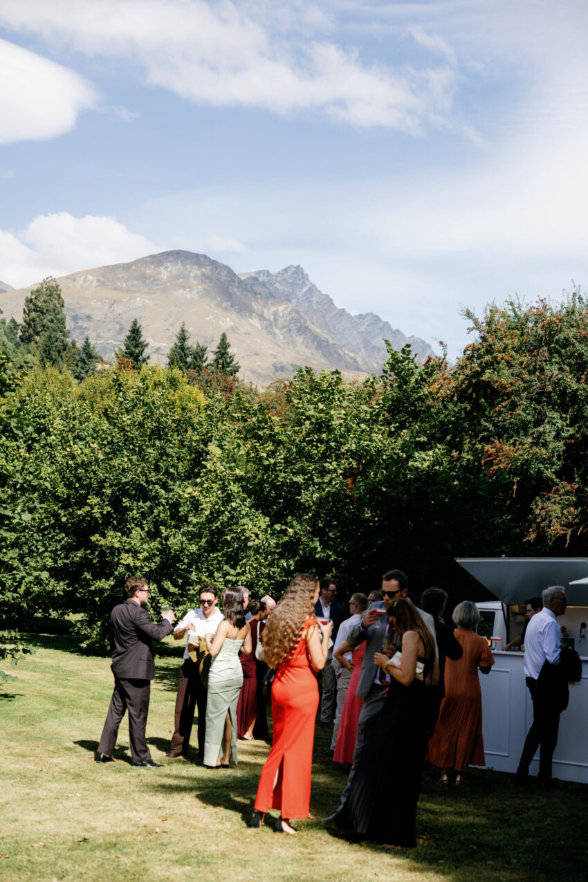 wide shot of guests at the cocktail bar with mountains in the background
