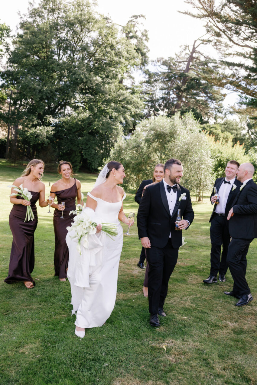 Bridal party walking along casually with drinks
