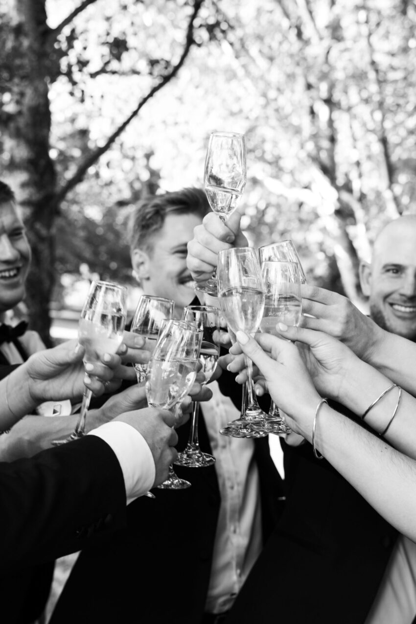 close up shot of many hands cheersing drinks