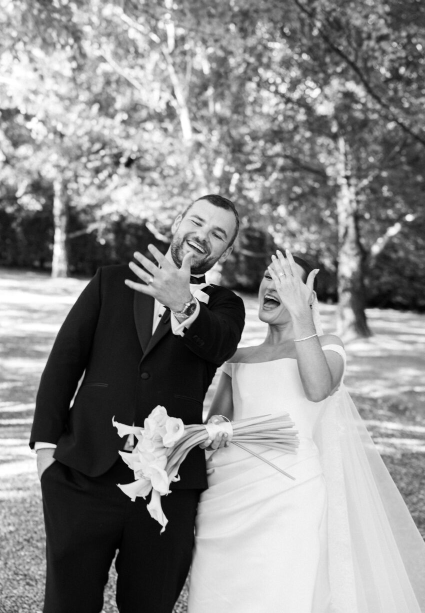 Bride and Groom candidly showing off their new wedding rings on their fingers