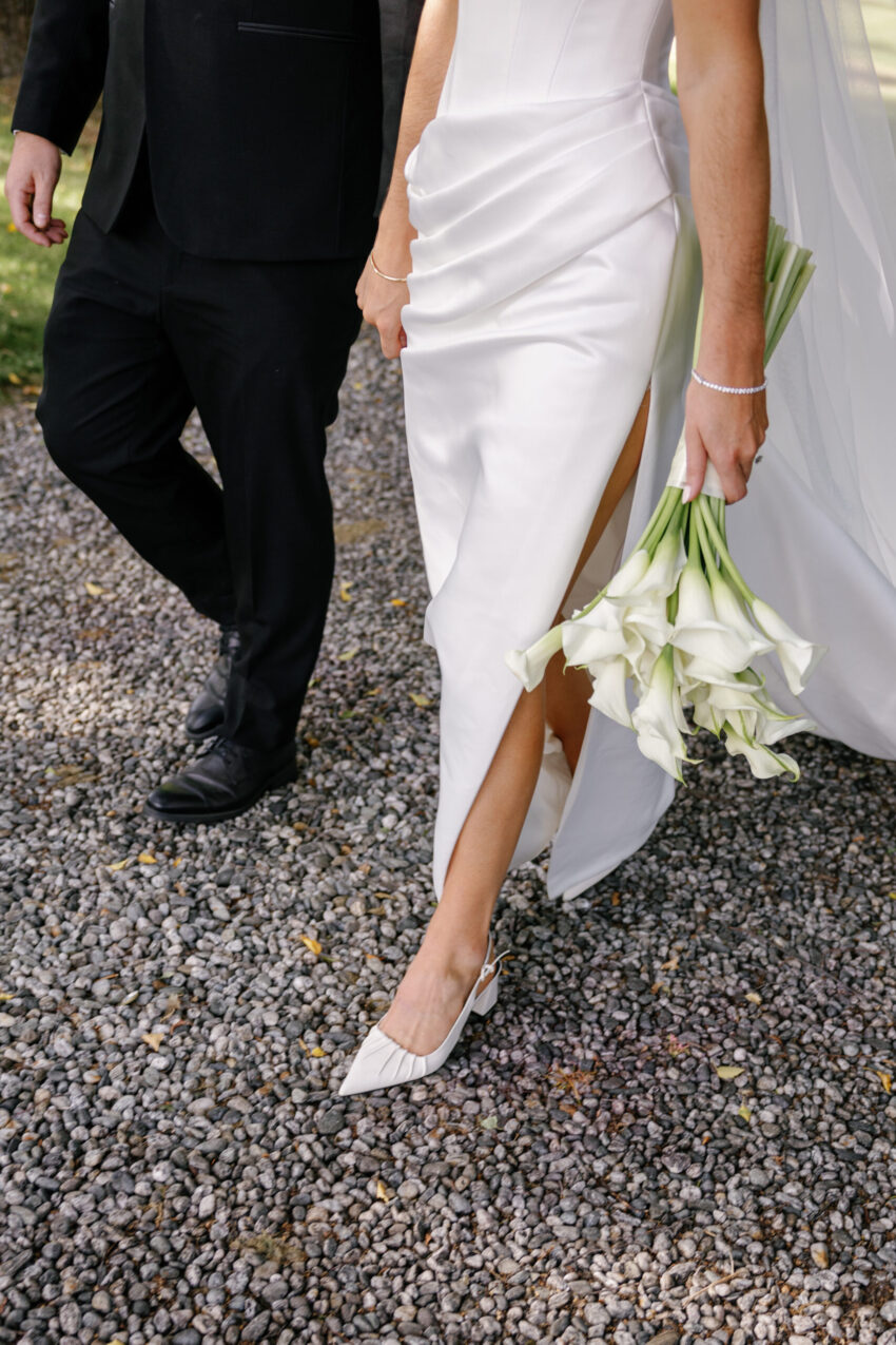 close up of Bride and Grooms legs and feet showing the brides shoes and flowers
