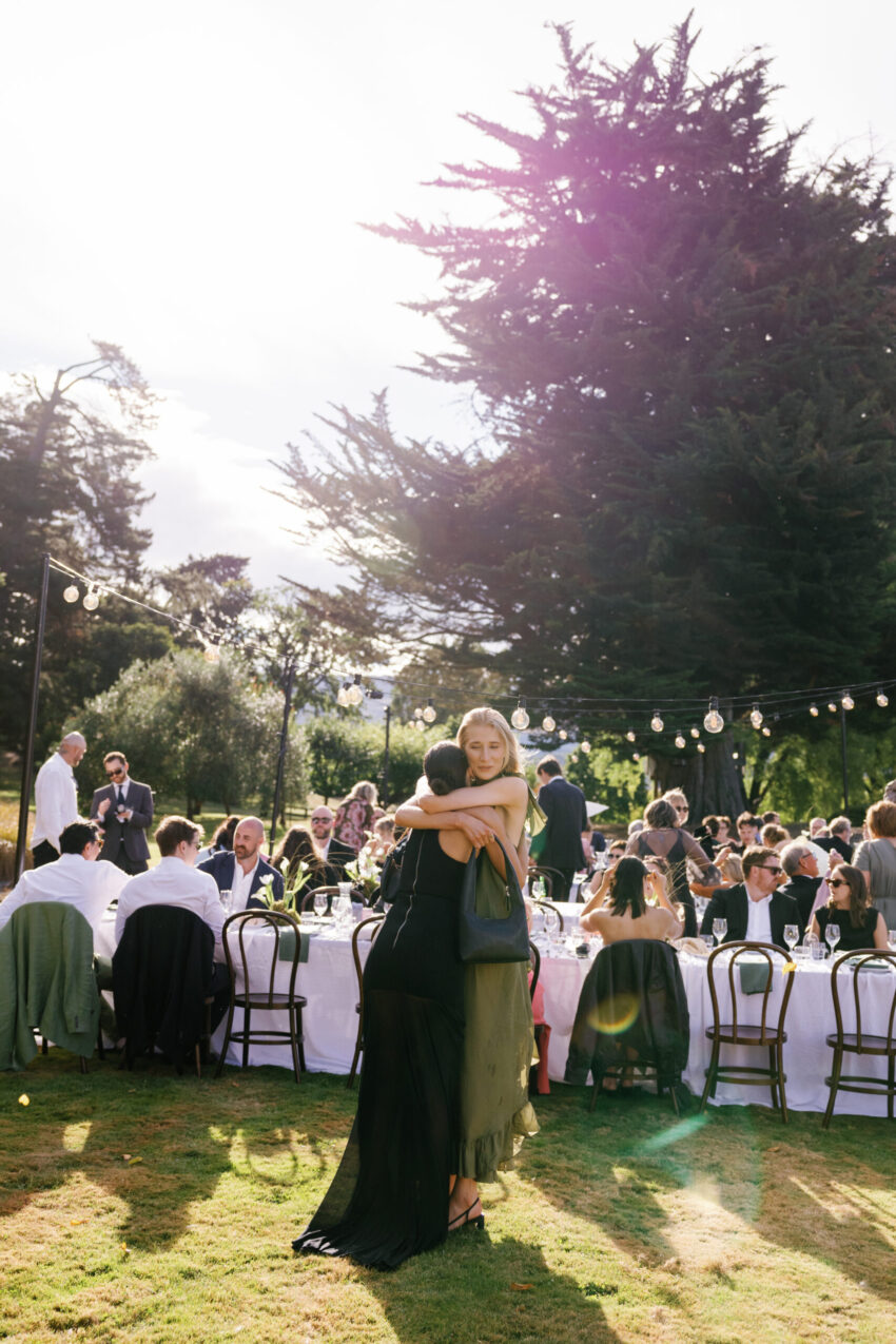Two guests hugging as the reception begins