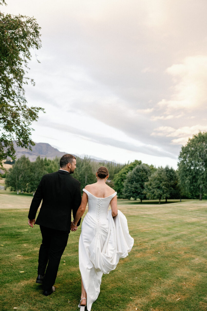 Bride and groom walk towards a beautiful scene