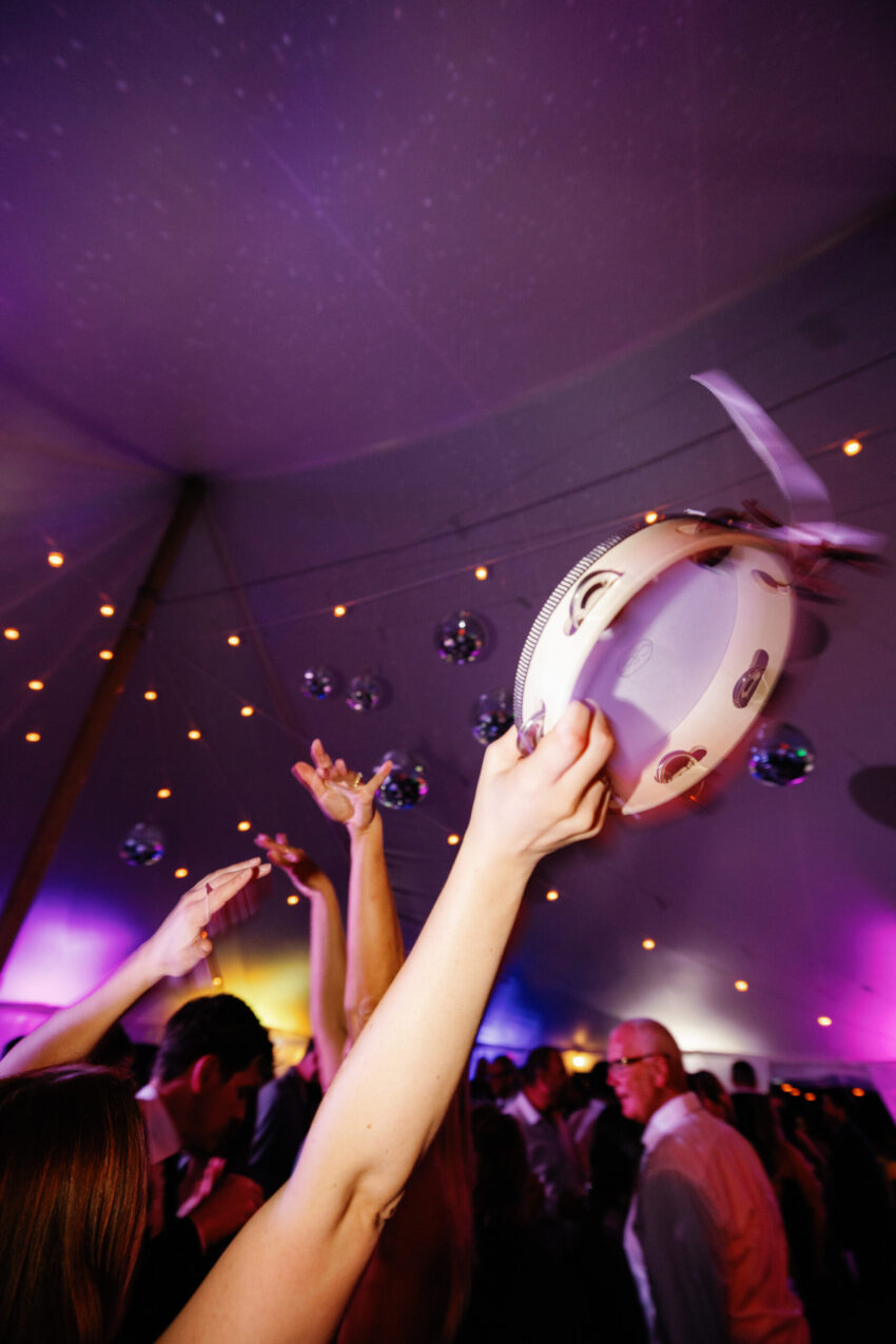 Tamborine in a guests hand in the air on the dancefloor
