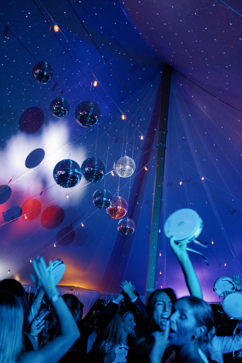 Brightly coloured party lighting, disco balls and a full dancefloor