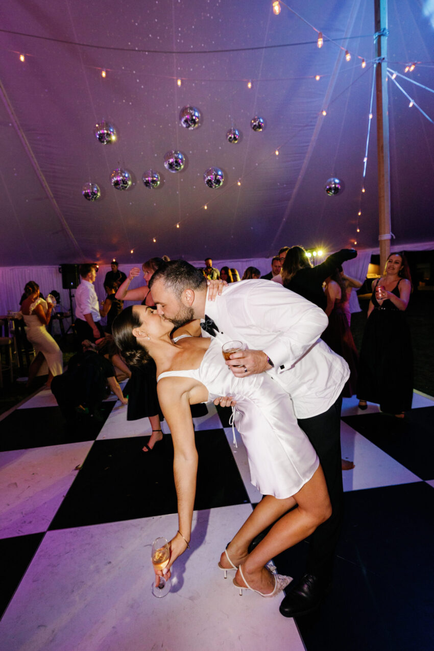 Bride and groom kissing on the dancefloor, the bride now wears a short dress