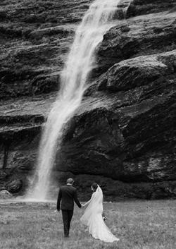Bride and groom in front of a waterfall in NZ